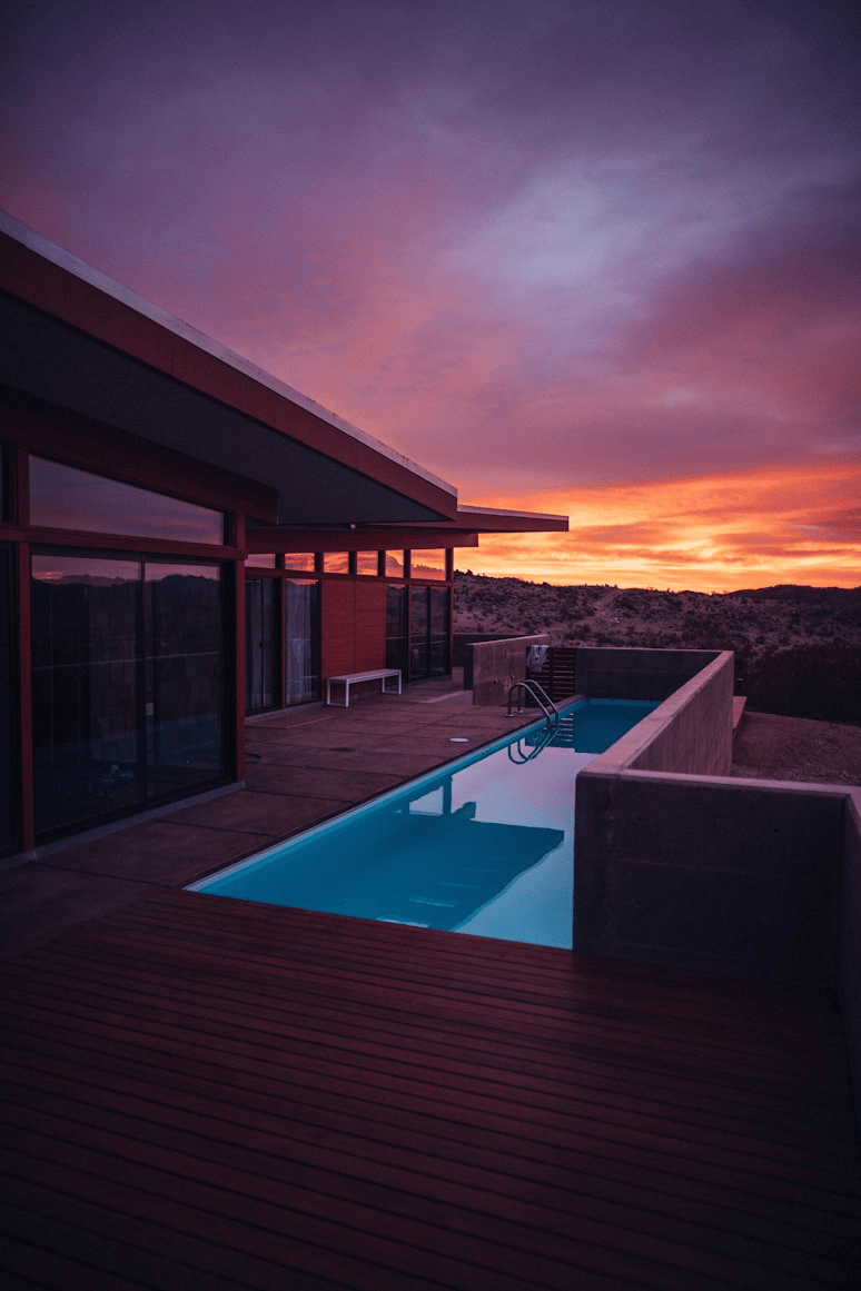 Modern desert house with lap pool at sunset