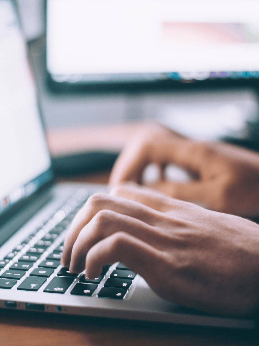 Hands typing a blog post on a laptop