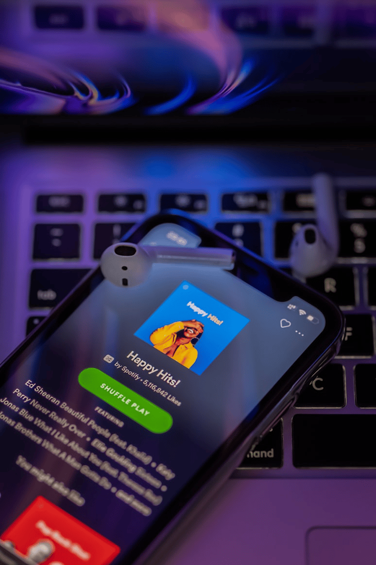 Smartphone showing the Spotify app on a laptop keyboard